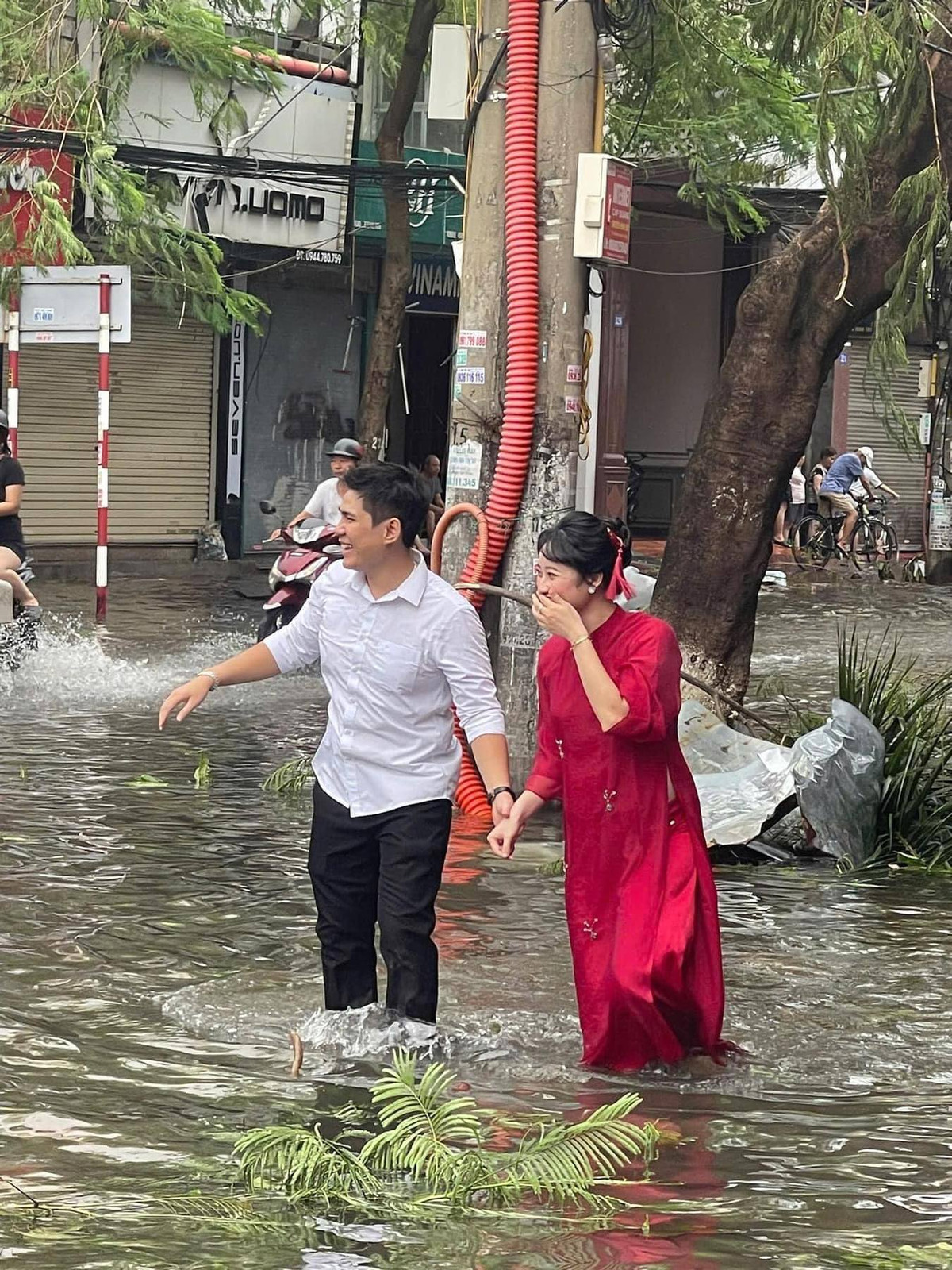 Theo đó, trong loạt ảnh được đăng tải, cặp đôi này nắm tay nhau bì bõm lội nước, chú rể mặc sơ mi trắng, còn cô dâu mặc chiếc áo dài đỏ truyền thống.