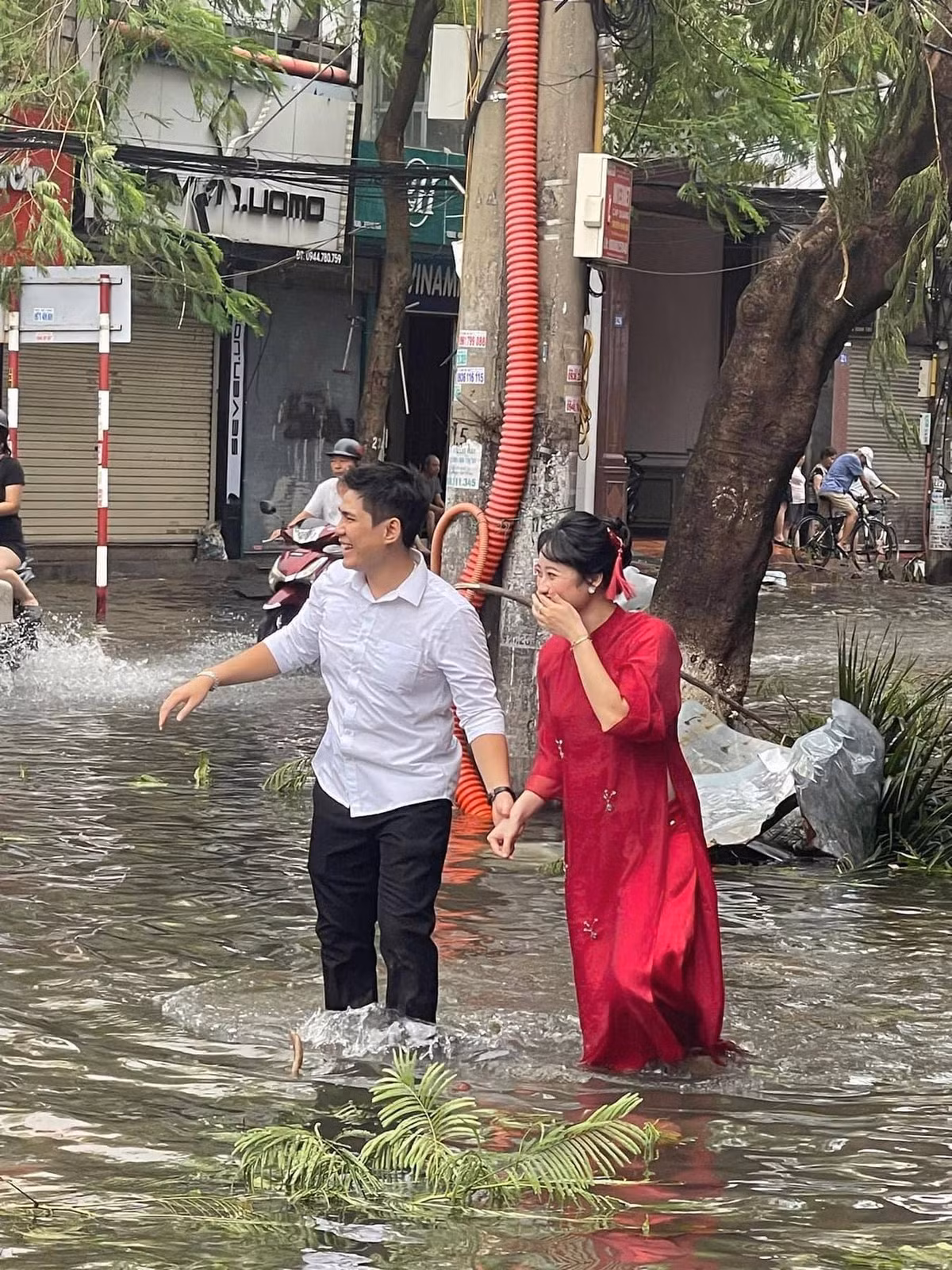 Theo đó, trong loạt ảnh được đăng tải, cặp đôi này nắm tay nhau bì bõm lội nước, chú rể mặc sơ mi trắng, còn cô dâu mặc chiếc áo dài đỏ truyền thống.
