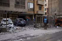 Lực lượng cứu hộ kiểm tra hiện trường một tòa nhà bị hư hại sau vụ không kích tại khu dân cư ở Lebanon, nhiều phương tiện bị phá hủy và mảnh vỡ vương vãi trên đường phố, cho thấy mức độ tàn phá của các đợt giao tranh leo thang.