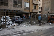 Lực lượng cứu hộ kiểm tra hiện trường một tòa nhà bị hư hại sau vụ không kích tại khu dân cư ở Lebanon, nhiều phương tiện bị phá hủy và mảnh vỡ vương vãi trên đường phố, cho thấy mức độ tàn phá của các đợt giao tranh leo thang.