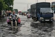 Mưa trái mùa, người dân TP HCM bì bõm trong nước ngập
