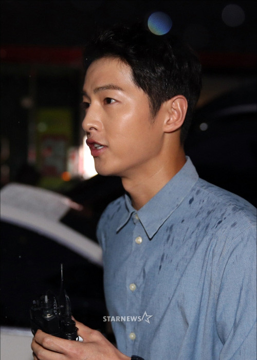 Mặc dù trời đổ mưa to nhưng Song Joong Ki vẫn dành thời gian trả lời báo chí truyền thông. Ảnh: Starnews