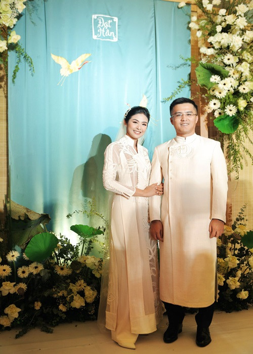 Áo dài cưới của Ngọc Hân tông màu trắng, họa tiết hoa sen. Chú rể cũng diện áo dài trắng. Ảnh: VTV