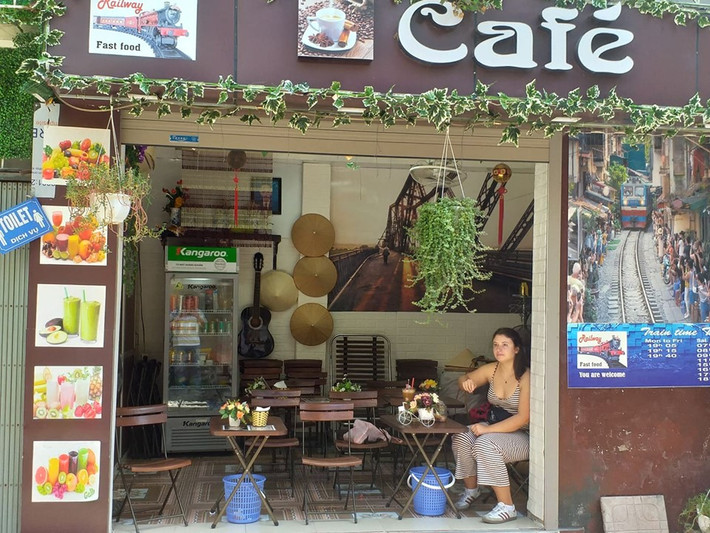 Một nữ du khách Tây ngồi ngẩn ngơ, tiếc nuối vì phố cà phê đường tàu bị cấm.