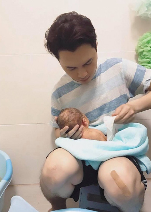 Từ khi vợ sinh con, Nam Cường giảm bớt công việc để chăm sóc gia đình. Trong ảnh, nam ca sĩ tự tay tắm gội cho cậu quý tử. Ảnh: FBNV
