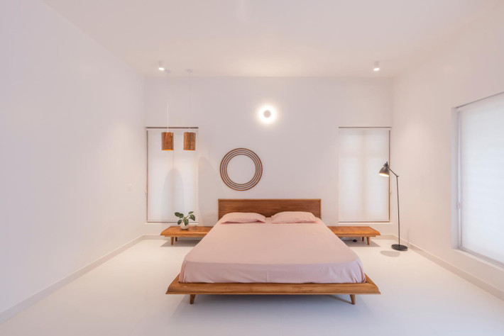 Phòng ngủ lớn bày biện tối giản để tập trung vào việc nghỉ ngơi, thư giãn.