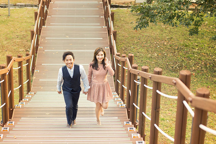 Hình ảnh Tiến Đạt nắm tay bà xã 9x dạo bước trên cây cầu gỗ.