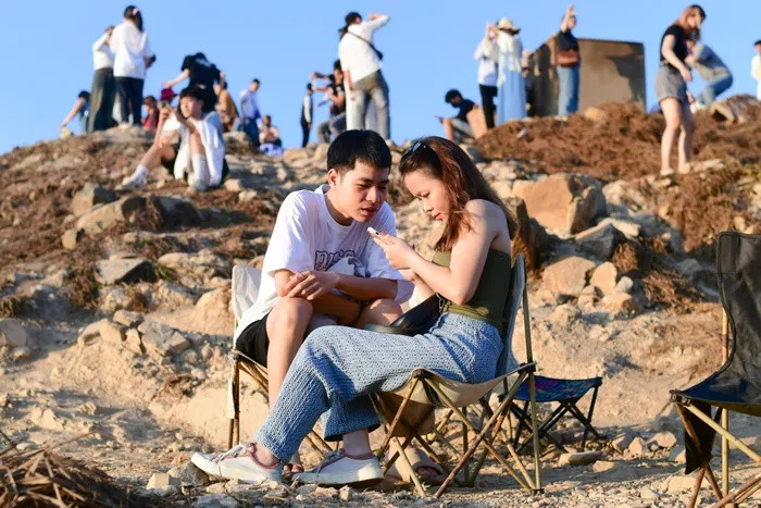 Đến đây từ lúc 5h, Thiên và Thảo (sống tại Bình Phước) đã tranh thủ ghi lại những bức ảnh đẹp với khoảnh khắc bình minh lên rực rỡ. "Chúng tôi biết đến địa điểm này thông qua clip TikTok nên quyết định tìm đến đây trong chuyến du lịch 3 ngày 2 đêm ở Vũng Tàu. Đây là lần đầu tiên cả 2 đặt chân đến mũi Nghinh Phong, nơi đây rất đẹp, gió mát, di chuyển khá dễ", Thiên nói. Nam du khách cho biết anh đã mua nước với giá 30.000 đồng/ly để có ghế ngồi, mức giá khá hợp lý.