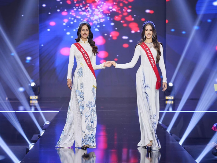 Các thí sinh trình diễn theo cặp ở phần thi trang phục áo dài. Ảnh: Miss Charm