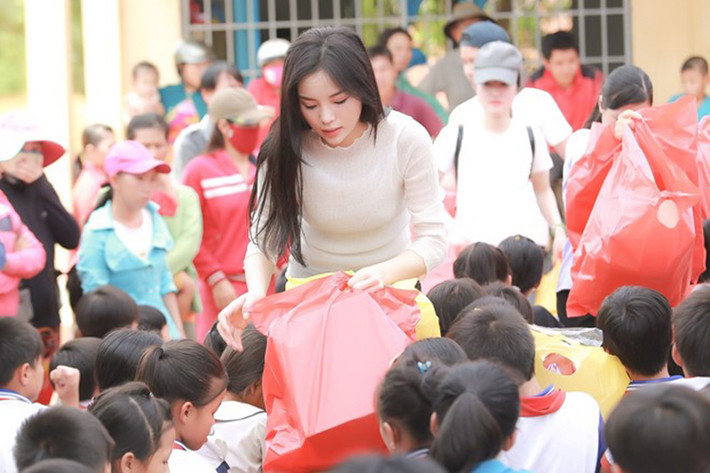 Trong hành trình từ thiện, người đẹp gốc Nam Định đã tự tay trao quà cho các em học sinh tại ngôi trường ở xã Tân Hòa. Kỳ Duyên còn cùng một vài người trong đoàn mượn xe máy để xuống thăm những người dân nghèo sống ở ven sông. (Ảnh: Zing)
