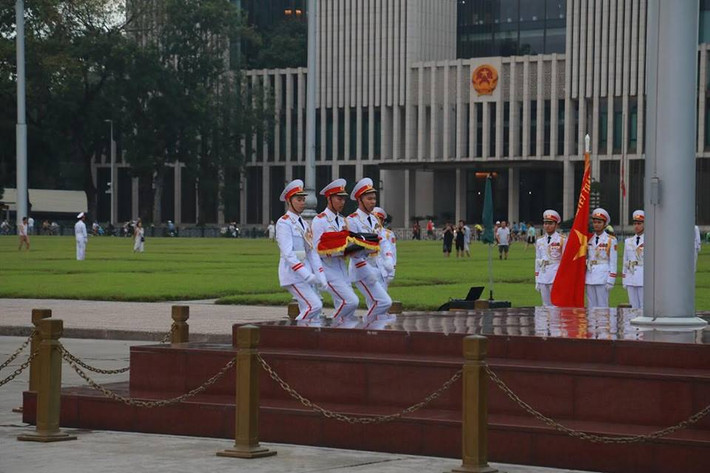 Ba chiến sĩ thực hiện nghi thức trang trọng tại chân cột cờ. Nghi lễ treo băng tang được tiến hành song song với nghi thức chào cờ thường ngày.