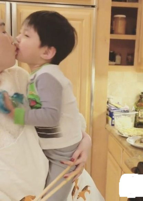 Theo đó, Ngọc Trinh một tay bế cháu trai của ông Hoàng Kiều một tay nấu ăn. Người đẹp còn âu yếm bón đồ ăn cho cậu bé. Ngọc Trinh cũng đã nhận được nụ hôn môi đầy ngọt ngào từ bé trai này. Có thể thấy, cô rất biết cách chiều chuộng và lấy lòng trẻ con. (Ảnh: Instagram Ngọc Trinh)