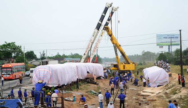 16h30 ngày 11/3, tuyến đường sắt sắp được thông trở lại, các toa tàu trật bánh được dựng dậy, phủ bạt che kín.