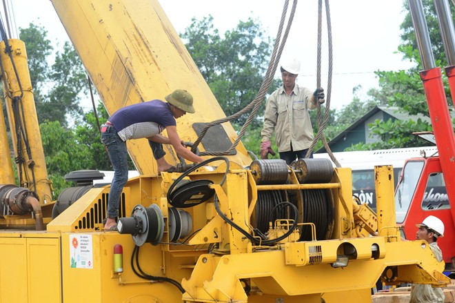 Quá trình nâng cần trục đường sắt gặp sự cố khi thiết bị khổng lồ này có biểu hiện mất an toàn, dễ bị gãy ở phần nối giữa thân máy với bộ phận cần cẩu nên công nhân phải móc dây vào giữ thân máy.