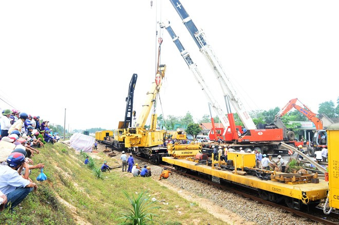 Khoảng 15h chiều 11/3, cần trục chuyên dụng đường sắt đã được nâng đứng trở lại nhưng vị trí bánh xe vẫn chưa nằm đúng trên hai thanh ray.