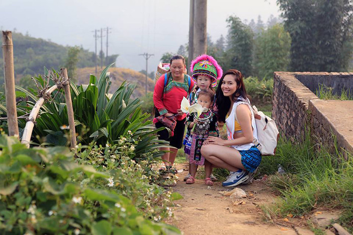 Á hậu Hoàng My chụp ảnh cùng 2 em bé đang trên đường đến chợ phụ mẹ bán búp bê ở Sapa.