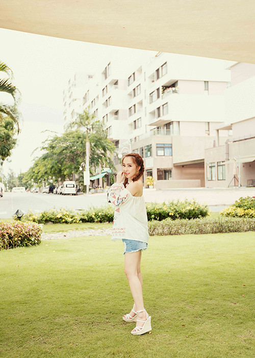 Bà xã Doãn Tuấn khéo léo phối áo trễ vai với quần short jeans và sandal đế xuồng tông màu trắng.