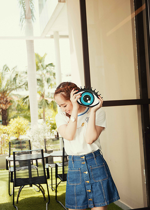 Lựa chọn phong cách thời trang Hàn Quốc, Quỳnh Nga kết hợp trang phục với túi hình con mắt ngộ nghĩnh.