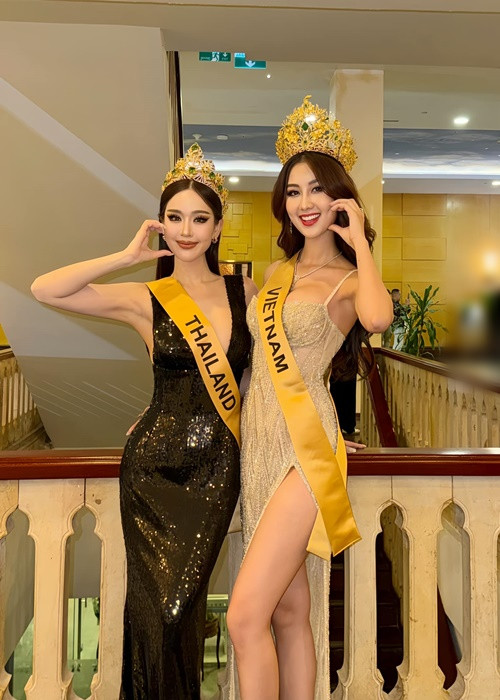 Đại diện Việt Nam mặc váy xẻ tà cao, tự tin đọ vẻ gợi cảm bên đại diện Thái Lan. Ảnh: FB Quế Anh.