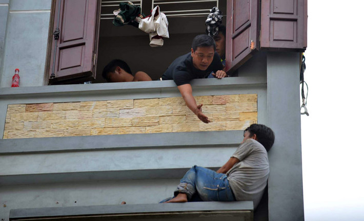 Đối tượng hoảng loạn khi bị khống chế và chứng kiến một lượng lớn người phía dưới đã vùng vẫy nhảy khỏi mái tôn ngôi nhà bên cạnh xuống đệm hơi và rơi xuống đất bị thương.