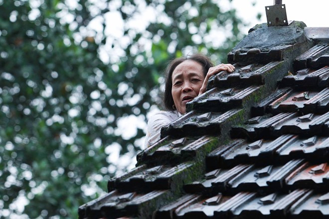 Bà Đặng Thị Hương (xã Phương Điền, Hương Khê) phải tạm trú trên mái nhà vì nước dâng cao, ngập hết các phòng.