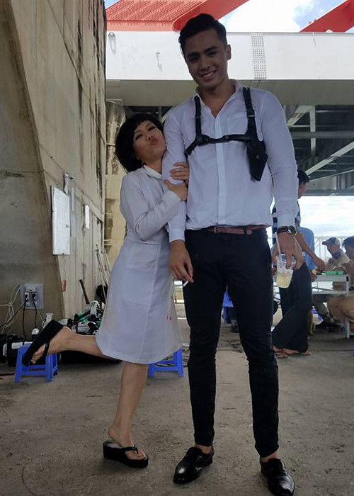 Nữ danh hài chu môi nhí nhảnh bên bạn diễn có chiều cao "khủng" trên phim trường. (Ảnh: FBNV)