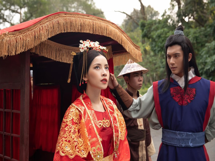 Lâm Bảo Châu xuất hiện chớp nhoáng trong 2 phân cảnh, khi che ô cho chị em Tấm, Cám và mở rèm che kiệu lúc Cám nhập cung làm hoàng hậu. Ảnh: FBNV