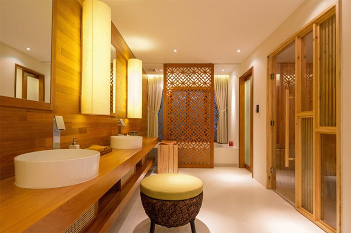 Phòng tắm rộng thoáng với vách trang trí gỗ kết hợp với chất liệu vải của màn, đèn tạo ra không gian thư giãn.
