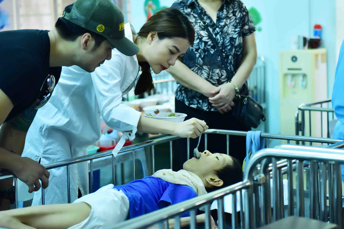 Trương Ngọc Ánh ân cần bón cơm cho một em nhỏ. Trong hoạt động này, cô đã thay mặt công ty của mình trao những phần quà có giá trị cho đại diện của trung tâm.