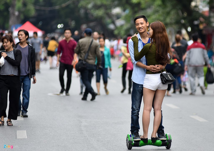 Đôi trai gái ôm nhau khi đi xe điện thăng bằng. Sau khi bị ngã khỏi xe do không kiểm soát được tốc độ, họ vẫn chơi tiếp theo cách như vậy.