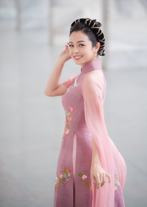 Mẫu áo dài cách tân có gam màu trầm nhã nhặn mang đến nét duyên dáng, thùy mị cho Hoa hậu Jennifer Phạm.