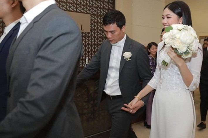 Thanh Tú mặc áo dài trắng, nắm chặt tay ông xã trong lễ rước dâu. Ảnh: Vietnamnet