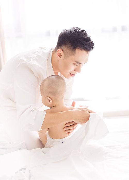 Việt Anh “Người phán xử” khéo léo mặc đồ và chơi với cậu con trai tròn 7 tháng tuổi.