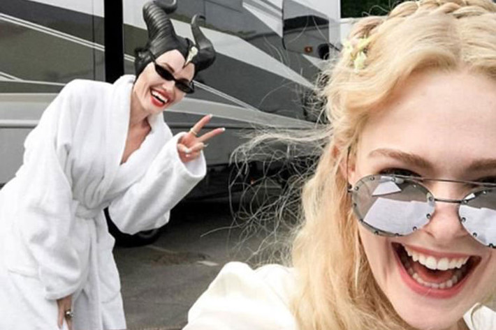 Angelina Jolie hiện rất bận rộn trên phim trường "Maleficent 2". Trong ảnh, Angelina Jolie nhí nhảnh tạo dáng bên nữ diễn viên Elle Fanning ở hậu trường phim "Maleficent 2" quay tại London, Anh.