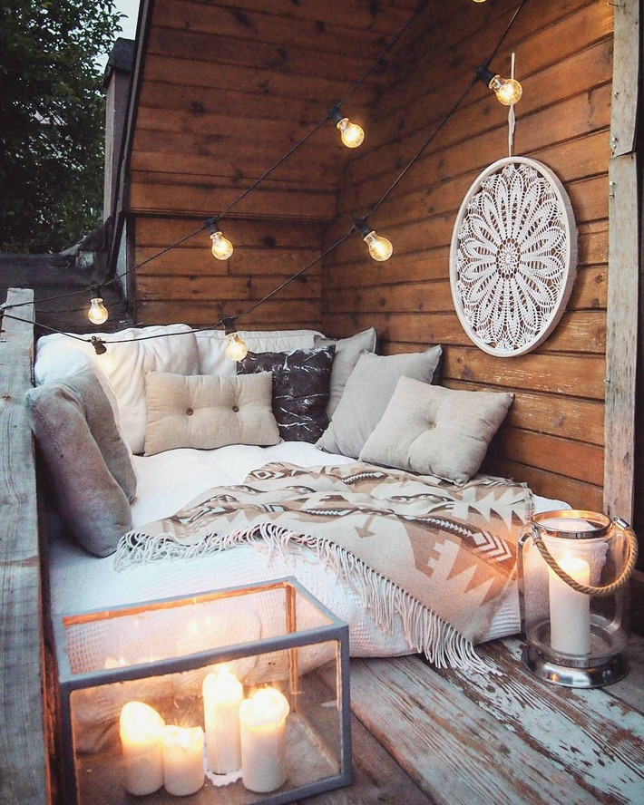 Ghế sofa nhỏ nhưng ấm cúng cùng nhiều chiếc gối bài trí, đèn lồng nến cùng một chiếc dream catcher quá khổ.