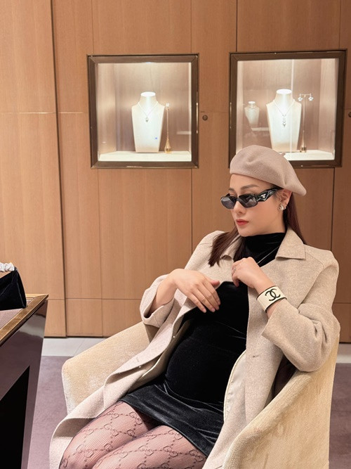 Xuống phố, Phương Oanh diện váy ngắn đen ôm sát cùng áo choàng. Nữ diễn viên chọn tất lưới làm phụ kiện nhằm tăng thêm độ quyến rũ cho set đồ. Ảnh: FBNV.