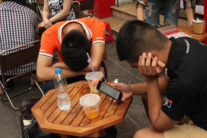 Hai anh đưa em trai đi thi ở trường THPT Phan Đình Phùng (Hà Nội). Những ngày này, các quán cà phê, trà đá quanh điểm thi hoạt động hết công suất.