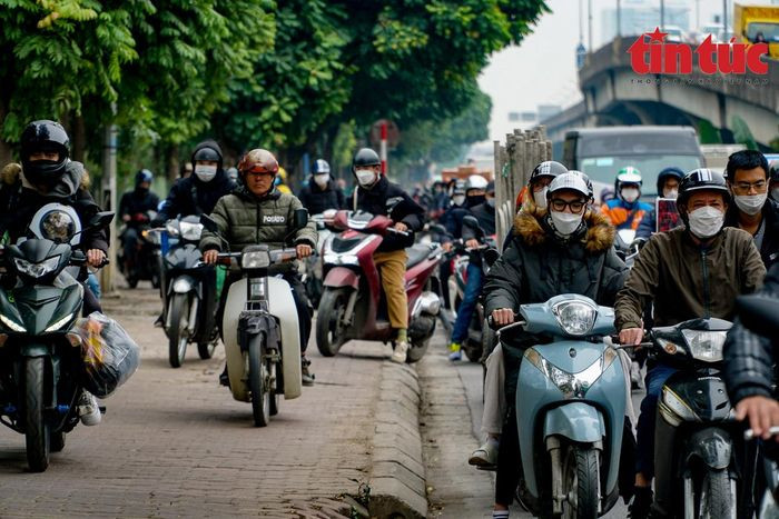 Trên đường Nguyễn Xiển (hướng Hà Nội đi cao tốc Pháp Vân), xe máy phải leo cả lên vỉa hè tìm lối thoát.