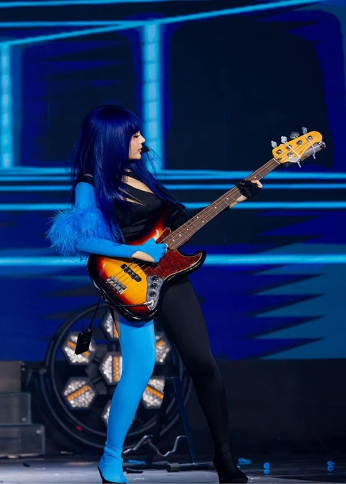 Hình ảnh Huyền Baby chơi guitar bass.