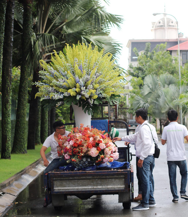 Bình hoa này cao trên 2m nên phải cần đến 4 nghệ nhân cắm hoa chuyên nghiệp mới cắm xong. Để vận chuyển các bình hoa này thì phải huy động xe 6 người phụ giúp mới có thể khiêng được. (Ảnh: Dân Việt).