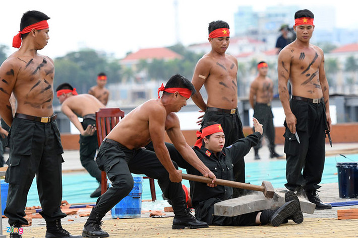 Một nữ chiến sĩ khác luyện cho đôi chân rắn khoẻ, chịu được lực đập của búa tạ công phá vỡ đá tảng trên ống đồng.