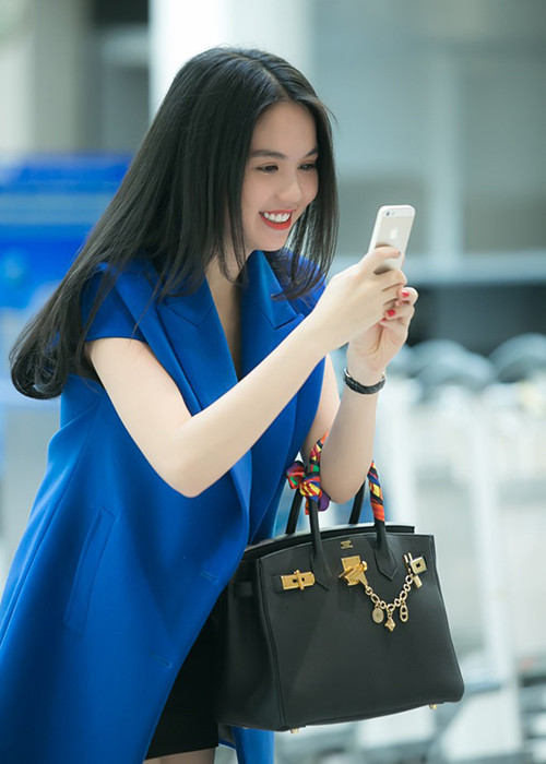 Nữ người mẫu sinh năm 1989 sành điệu với set đồ: trang phục crop-top tối màu, áo vest xanh cobalt cùng chiếc túi Hermes giá hơn 400 triệu đồng. (Ảnh: Zing)