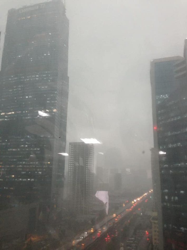 Dù mới 14h chiều (20/8), trời đang quang - sáng bỗng dưng tối sầm. Đến 14h30, mưa lớn bắt đầu trút xuống. Người lưu thông trên đường đều phải bật đèn pha, các cửa hàng, văn phòng cũng đua nhau sáng điện. (Ảnh PLO)