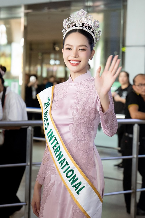 Tại sân bay quốc tế Tân Sơn Nhất, người đẹp diện trang phục áo dài truyền thống, đội vương miện.