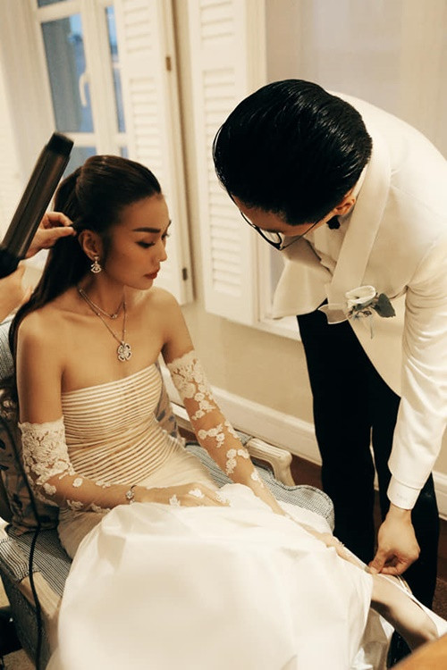 Siêu mẫu Thanh Hằng vừa tung loạt ảnh cưới hôm 22/10. Ở hậu trường hôn lễ, người đẹp được ông xã Trần Nhật Minh chỉnh sửa giày. Ảnh: FBNV.