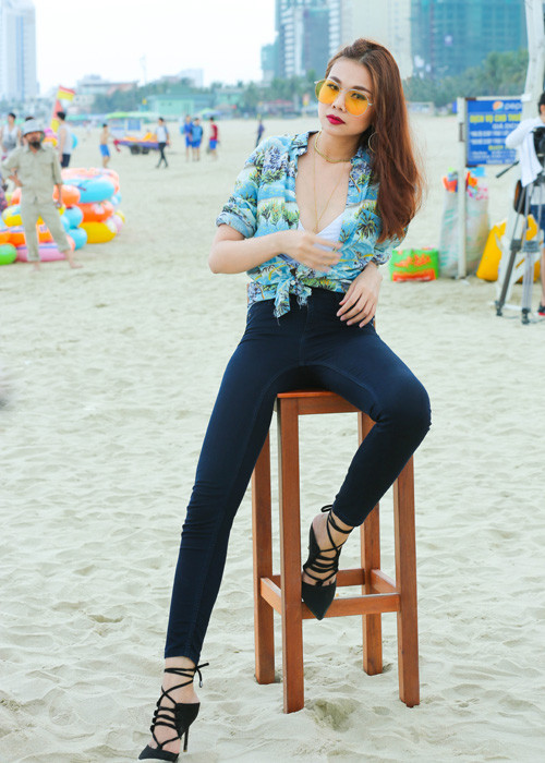 Siêu mẫu Thanh Hằng diện áo sơ mi xanh Saint Lauren họa tiết cây cọ và quần skinny jeans lưng cao của Zara.