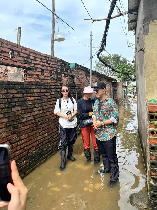 "Mọi người đứng lại đằng xa cho nước ngập sâu tí. Đứng ngập sâu, ra hẳn đằng kia đi. Máy chạy 3 2 1 bắt đầu", một người trong ê-kíp của Ưng Hoàng Phúc yêu cầu vợ chồng nam ca sĩ và Quế Vân. Ảnh: FB Quế Vân.