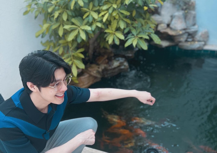 Nam ca sĩ thảnh thơi ngồi ngắm cá trong biệt thự.