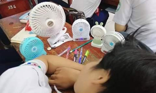 Mặc kệ ngoài kia nắng nóng, cậu bạn vẫn thoải mái hưởng thụ gió mát từ những chiếc quạt mini mang lại. Thế mới nói, mùa hè chẳng có gì đáng sợ nếu bạn sẵn sàng sắm cho mình dăm ba cái quạt bé nhỏ thần kỳ như này. Ảnh: Đồng Thiện Phúc.