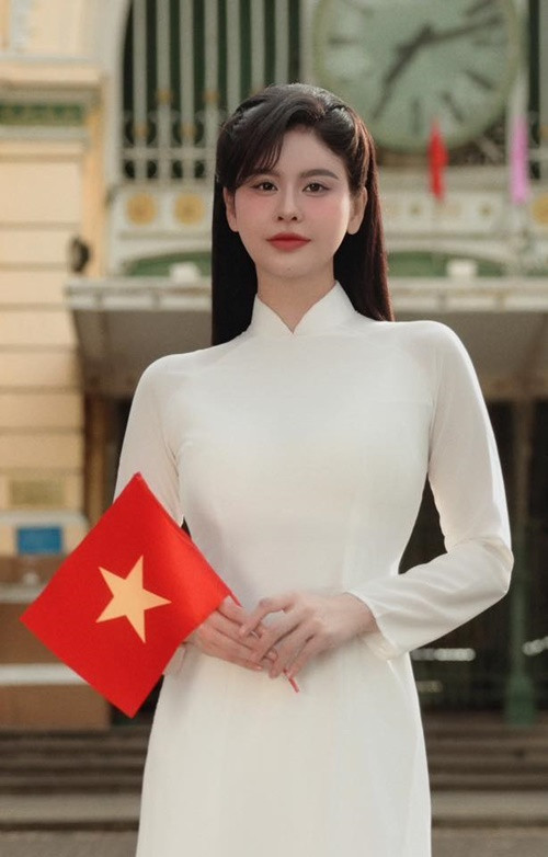 Trương Quỳnh Anh diện áo dài trắng tinh khôi, cầm lá cờ đỏ sao vàng. Ảnh: FB Trương Quỳnh Anh